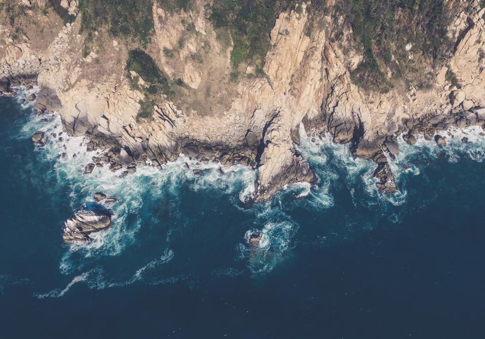 Aerial view of waves breaking on a rocky coastline