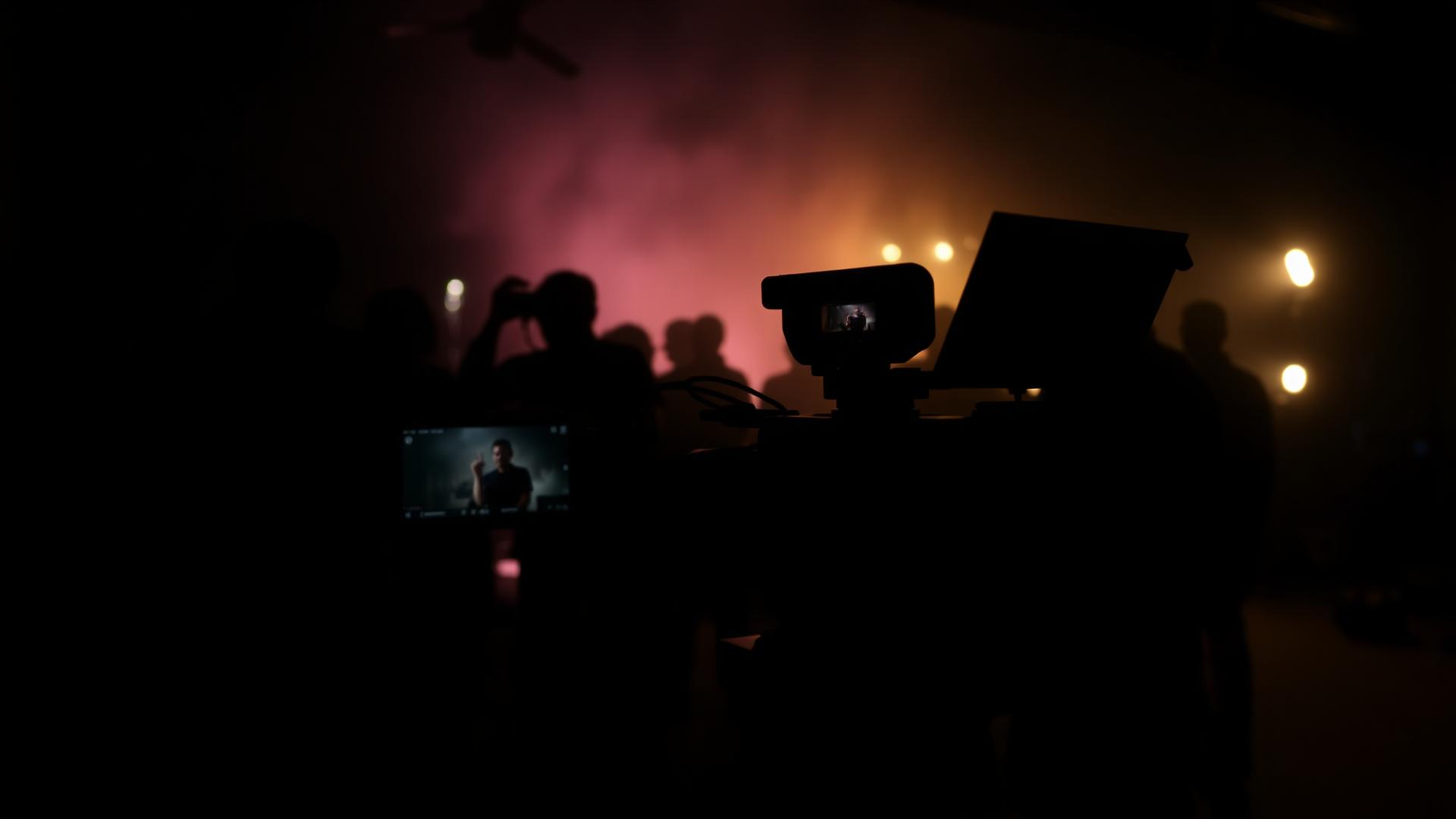 Cinema camera and crew silhouettes on a hazy film set